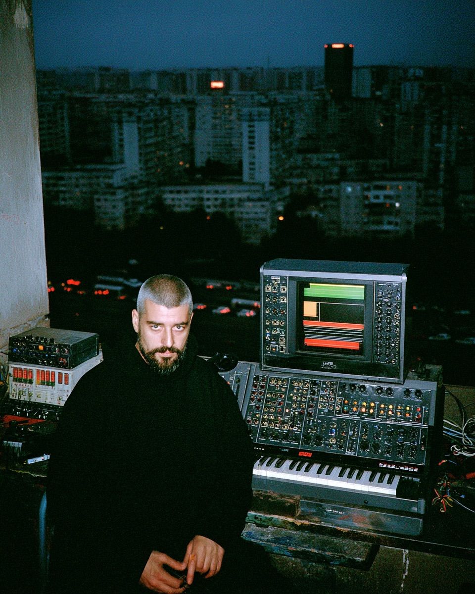 electronic musician with a modular synth rig at dusk